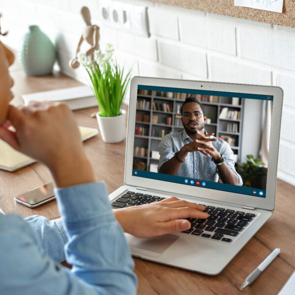 African,Girl,Student,Watching,Video,Course,,Distance,E-learning,,Studying,With African girl student watching video course, distance e-learning, studying with online teacher by webcam. Remote education, work from home concept. Over shoulder close up laptop mock up screen view.